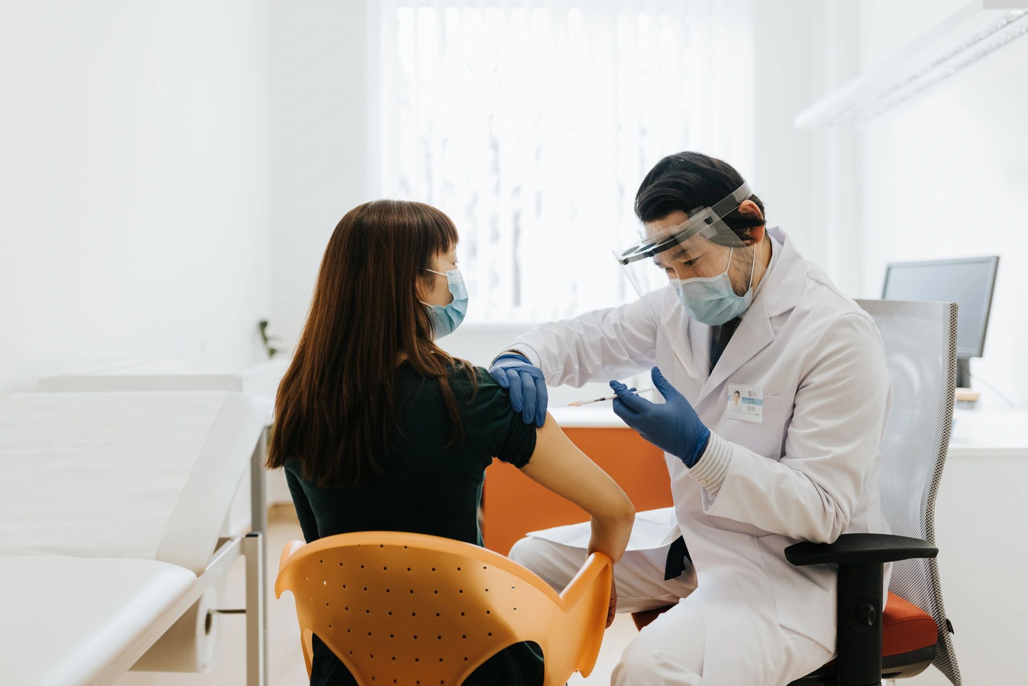Médico realizando procedimiento de inyección a paciente en entorno clínico