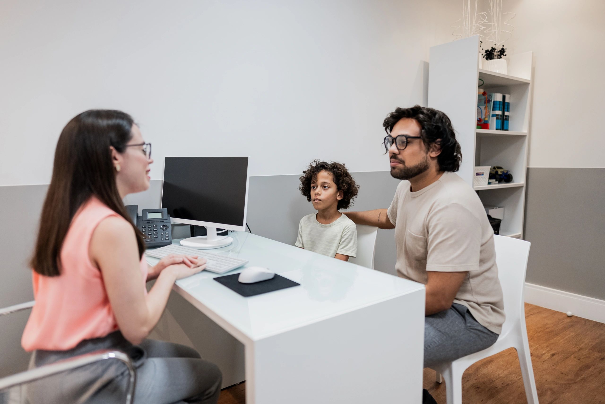 Padre e hijo conversando con un médico en clínica